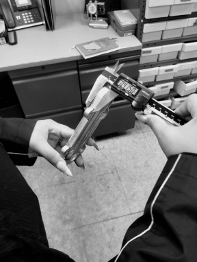 Measuring a part with calipers at Shawnee Specialties